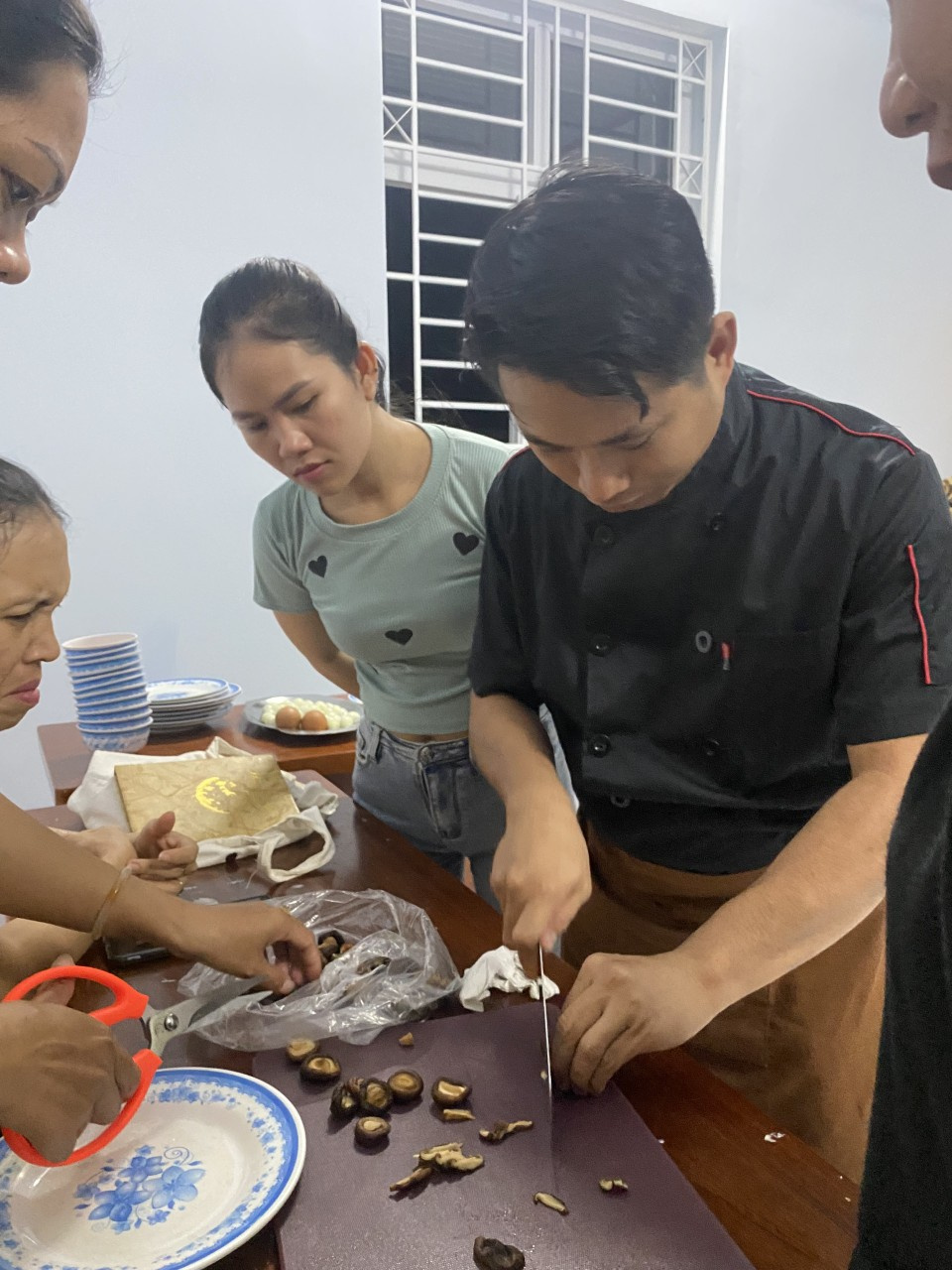 Thầy giáo hướng dẫn mọi người cắt thái nguyên liệu